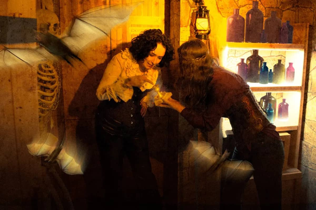 Players in a creepy room with a skeleton and bats